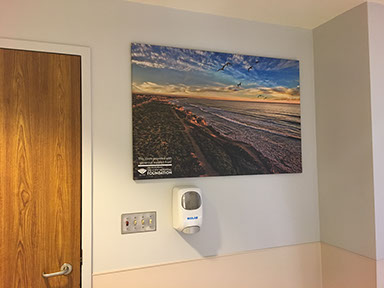 Framed canvas print of coastal cliffs hanging in an office